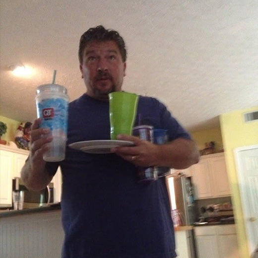 A dad holding dishes during cleanup